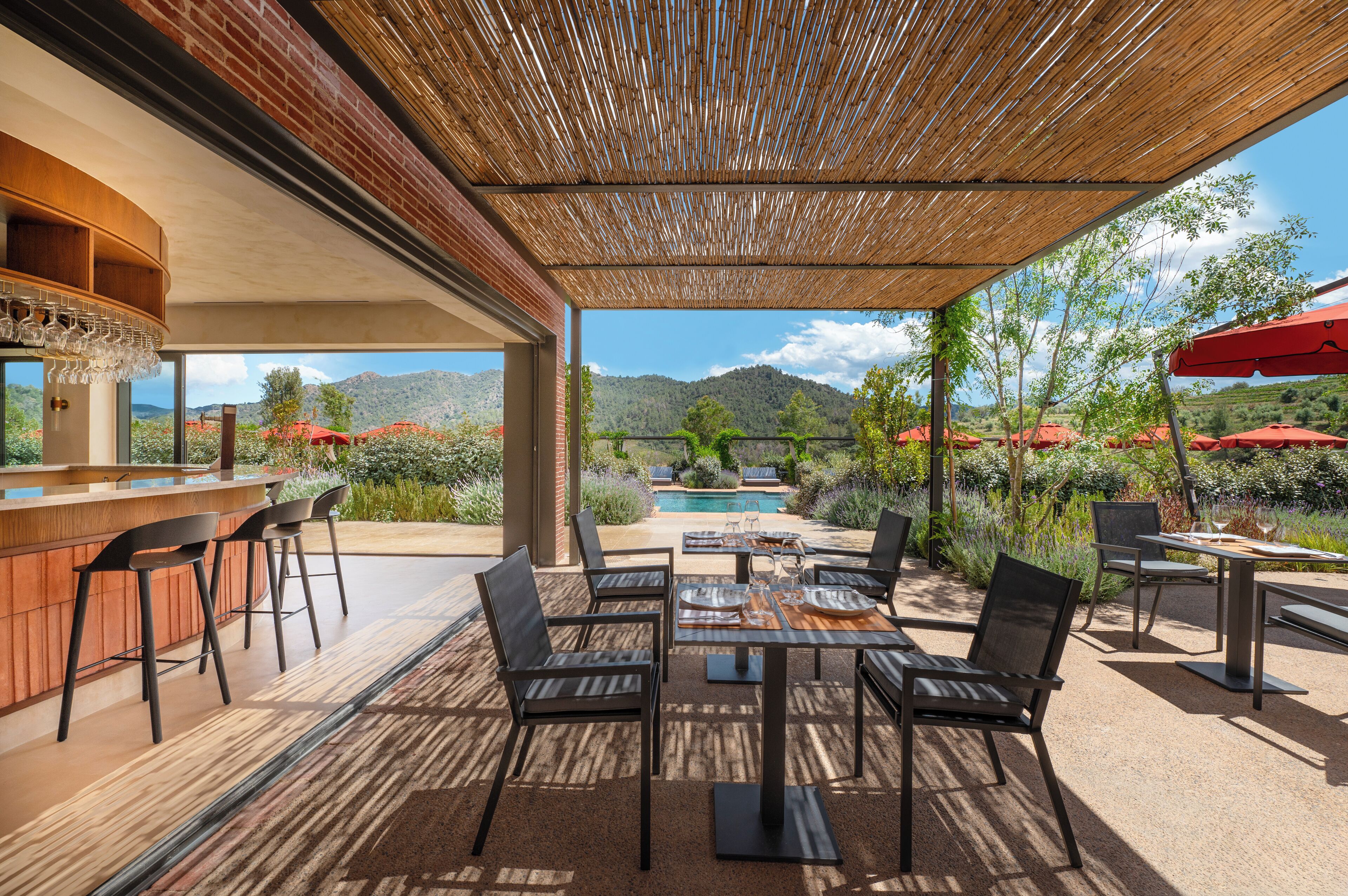 Un patio al aire libre con barra, asientos y vistas a las montañas.