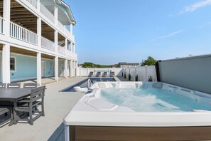 Relax on the balcony overlooking the water with a hot tub and dining area.