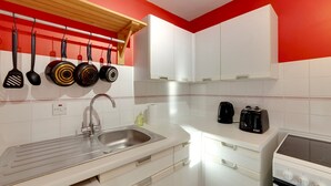 A modern kitchen with white cabinets, a stainless steel sink, and a range hood.