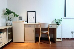 A compact workspace with a desk, chair, and shelving unit. - Shenzhen Life Home Apartment (Shenzhen Huaqiangbei Science Museum Subway Station) (Shenzhen)