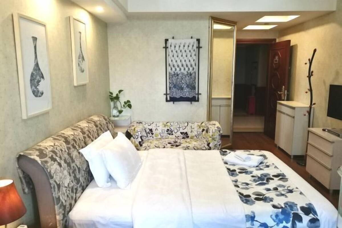 Una habitación de hotel con una cama, un sofá, un escritorio y un televisor.