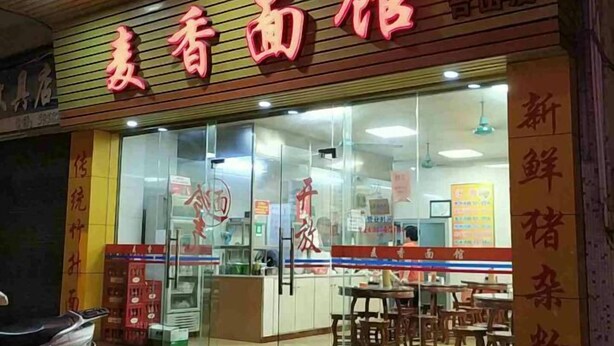 Un restaurante con un cartel de menú a la vista y una zona de mostrador.