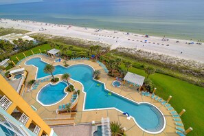 A resort with multiple swimming pools, a beach, and a view of the ocean.