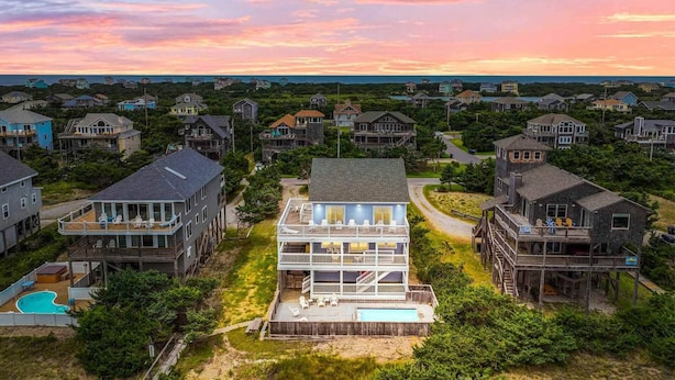A coastal residential area with multiple two-story houses, featuring balconies and a swimming pool.
