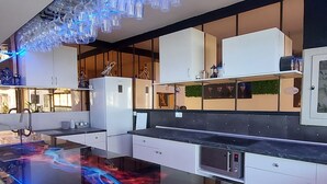 A modern kitchen with white cabinets, a black countertop, and a built-in microwave.