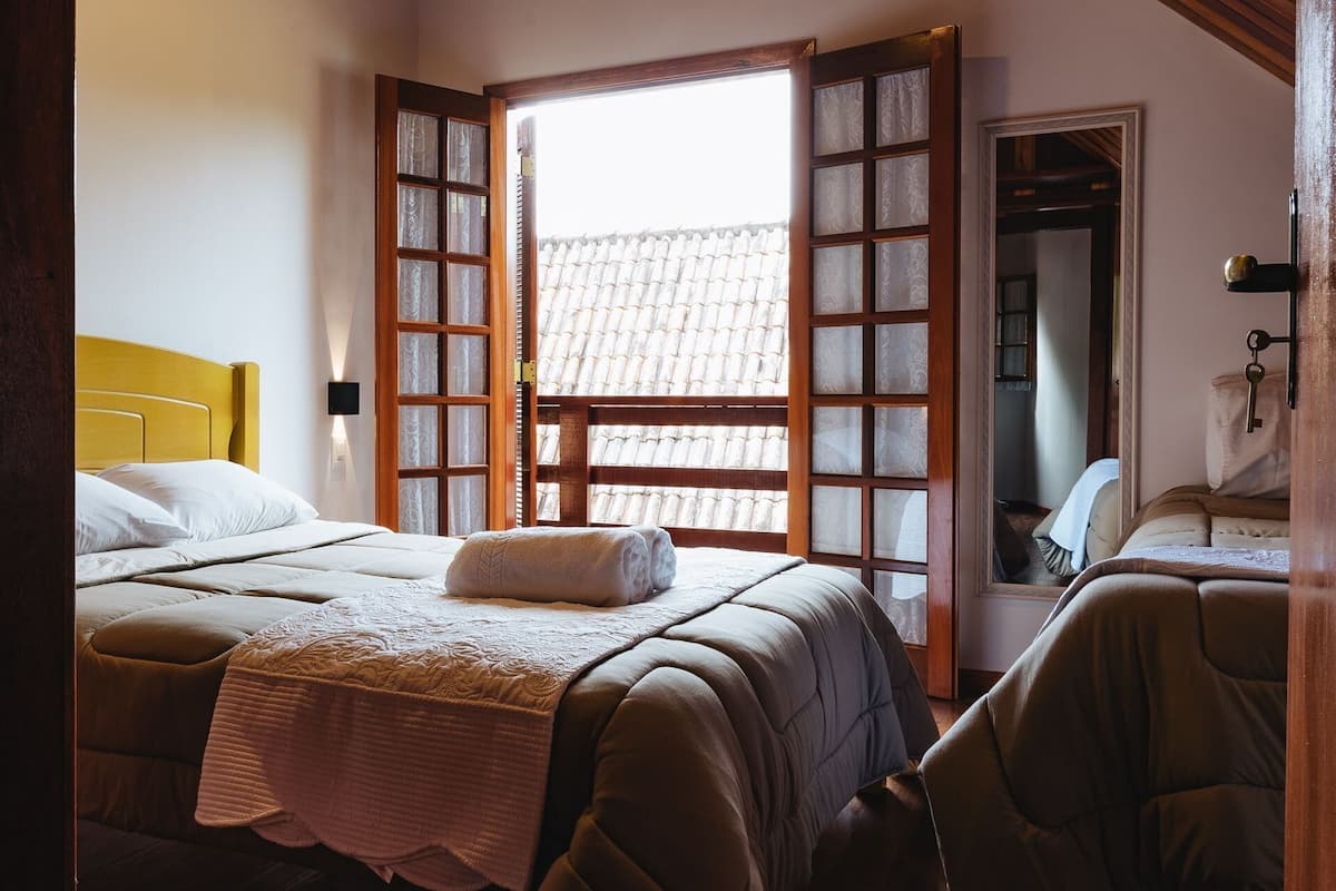 A bedroom with a bed, a chair, and a wardrobe.