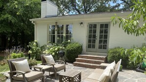 A patio with stone flooring and outdoor furniture, including two sofas and a table.