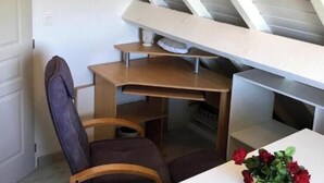 A room with a sloped ceiling, a desk, a chair, and a small table with a vase of flowers. - Gite Burgundy 71 near le PAL Basilique Cure thermale Rcea (La Motte-Saint-Jean)