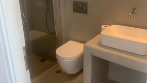 Un baño con inodoro, lavabo y ducha.