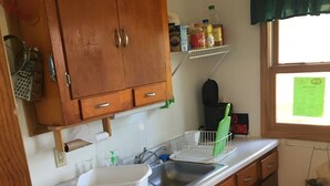 Una cocina con armarios de madera, un lavamanos blanco y una ventana con vistas.