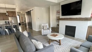 Ein modernes Wohnzimmer mit grauen Sofas, einem Couchtisch und einem Kamin.