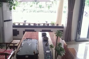 Un comedor con una mesa larga, sillas y vistas al exterior.