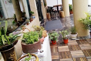 Un vestíbulo de hotel con suelo de madera, plantas en macetas y un área de descanso.