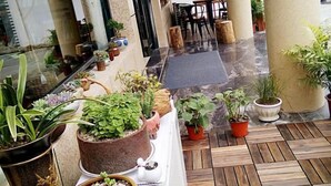 A hotel lobby with a variety of potted plants arranged on a central table and along the walls. - Xianyan Hotel (Yueqing)