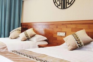 Habitación de hotel con dos camas, cada una con almohadas a juego y un cabecero de diseño geométrico.