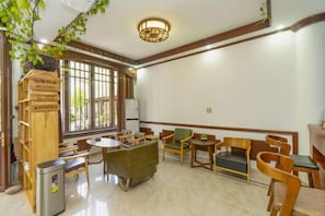 A hotel lobby with a reception desk, seating area, and a large window. - Xianyan Hotel (Yueqing)