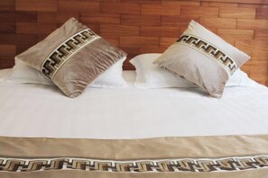Una cama con dos almohadas que presentan un diseño geométrico y un edredón con un diseño similar.