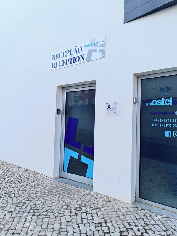 A reception area with a sign reading "RECEPCAO RECEPTION" and a door labeled "AL". - Hostel Supremo (Silves)