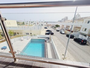 Un espace piscine offrant une vue dégagée sur la rue et les bâtiments environnants.