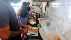 Un espace cuisine comprenant un comptoir, une personne qui coupe des aliments et divers ustensiles de cuisine.