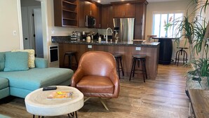 Une cuisine moderne avec des meubles en bois foncé, des appareils électroménagers en acier inoxydable et un îlot central.