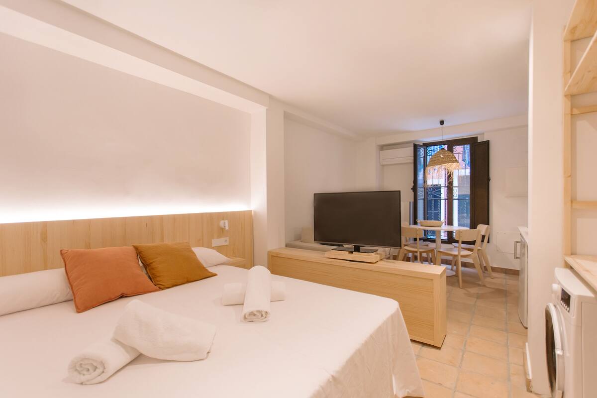 Une chambre d’hôtel équipée d’un lit, d’une télévision, d’un bureau et d’une machine à laver.