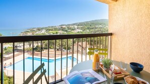 A balcony with a view of a swimming pool and a distant landscape. - La Gaillarde by Interhome (Les Issambres)
