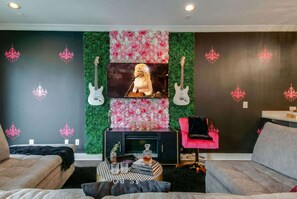 Un salón con chimenea, un televisor y dos guitarras.