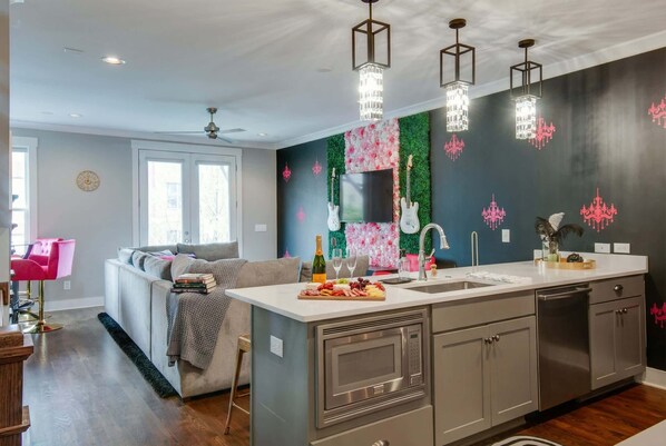 Una cocina moderna con una isla central, electrodomésticos de acero inoxidable y decoración mural.