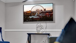 A TV mounted on a wall displaying a cityscape with a Ferris wheel.