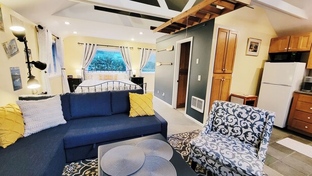 A compact living space with a sofa, a patterned armchair, a small table, and a kitchenette. - All the amenities of home with no cleaning fees and first breakfast included!  (West Linn)