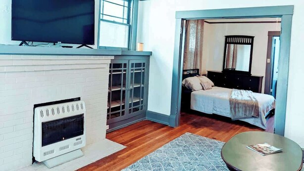 Ein modernes Zimmer mit Kamin, Fernseher und Bett.