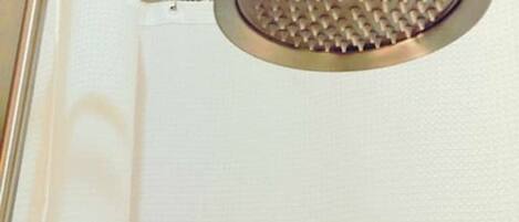A shower with a round head and a handheld showerhead.