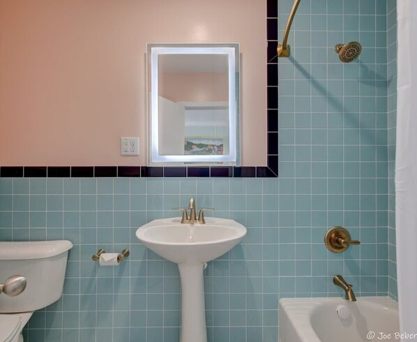 A bathroom with a sink, toilet, and bathtub.