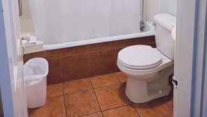 A bathroom with a shower curtain, a toilet, a bathtub, and a trash bin. - Unit 15 King Bedroom, Mini Fridge, Wifi, Coffee Ma (Hot Springs)