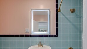 Et badeværelse med vask, toilet og badekar.