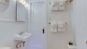 Une salle de bain avec un lavabo blanc, un miroir et un porte-serviettes.