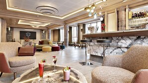 A spacious lobby with a bar area, seating arrangements, and a modern chandelier. - Wifi, ski-in/ski-out & foot of the slopes, fitness, swimming pool, sauna, hammam, balcony, tv (Valmorel)