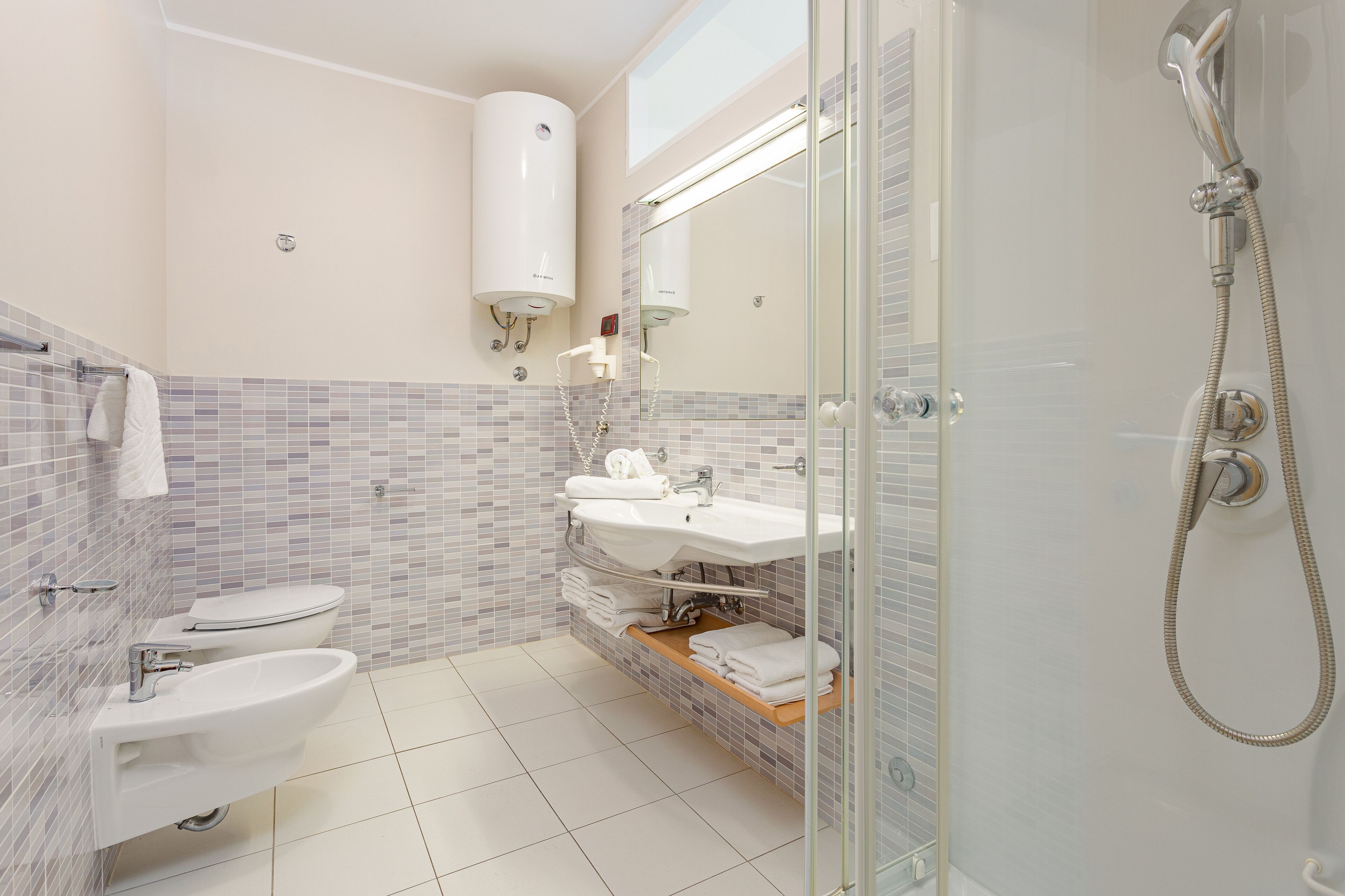 Une salle de bain moderne avec une douche à parois de verre, un lavabo blanc et des toilettes.