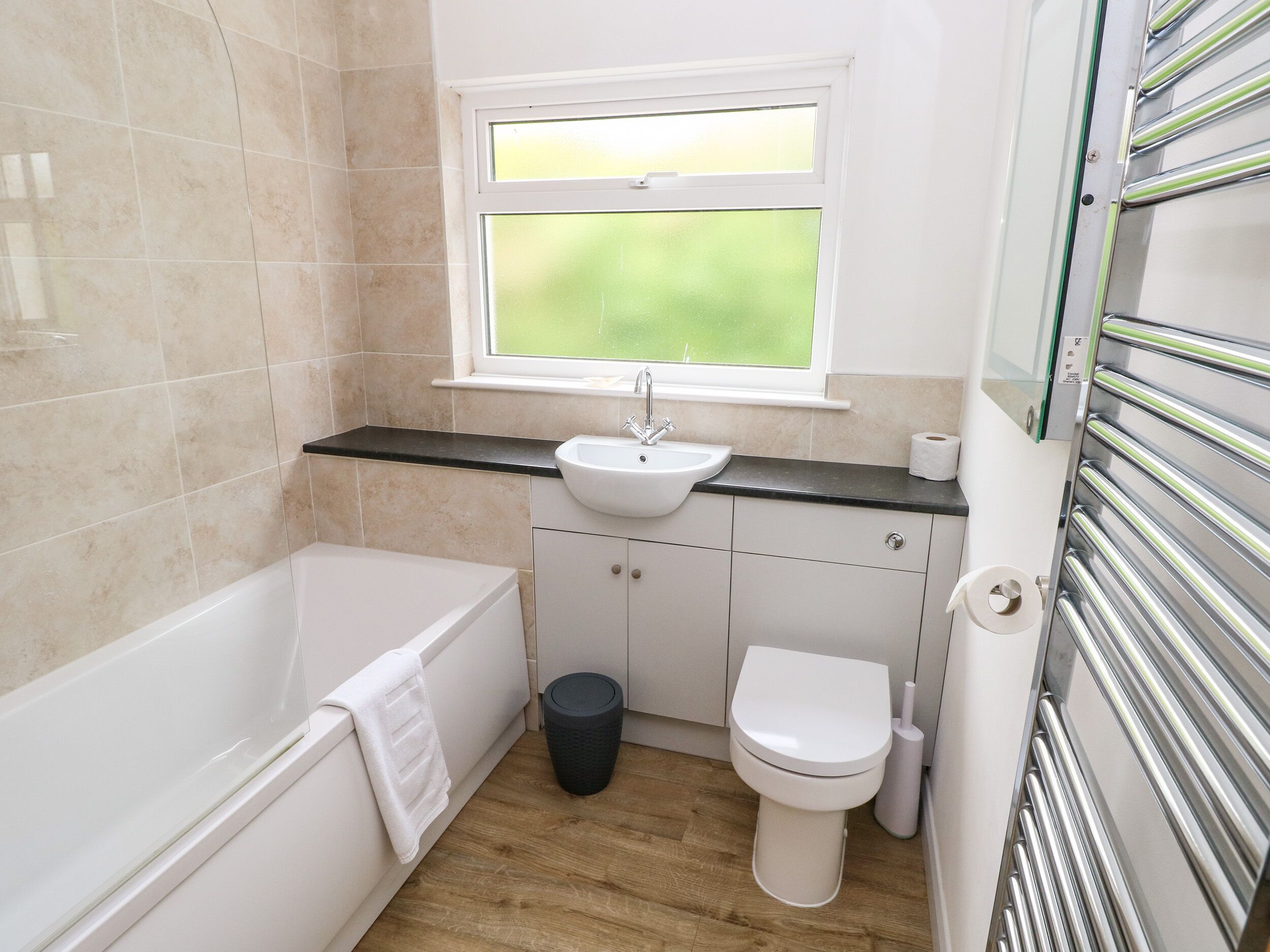 Et moderne badeværelse med badekar, vask og toilet.