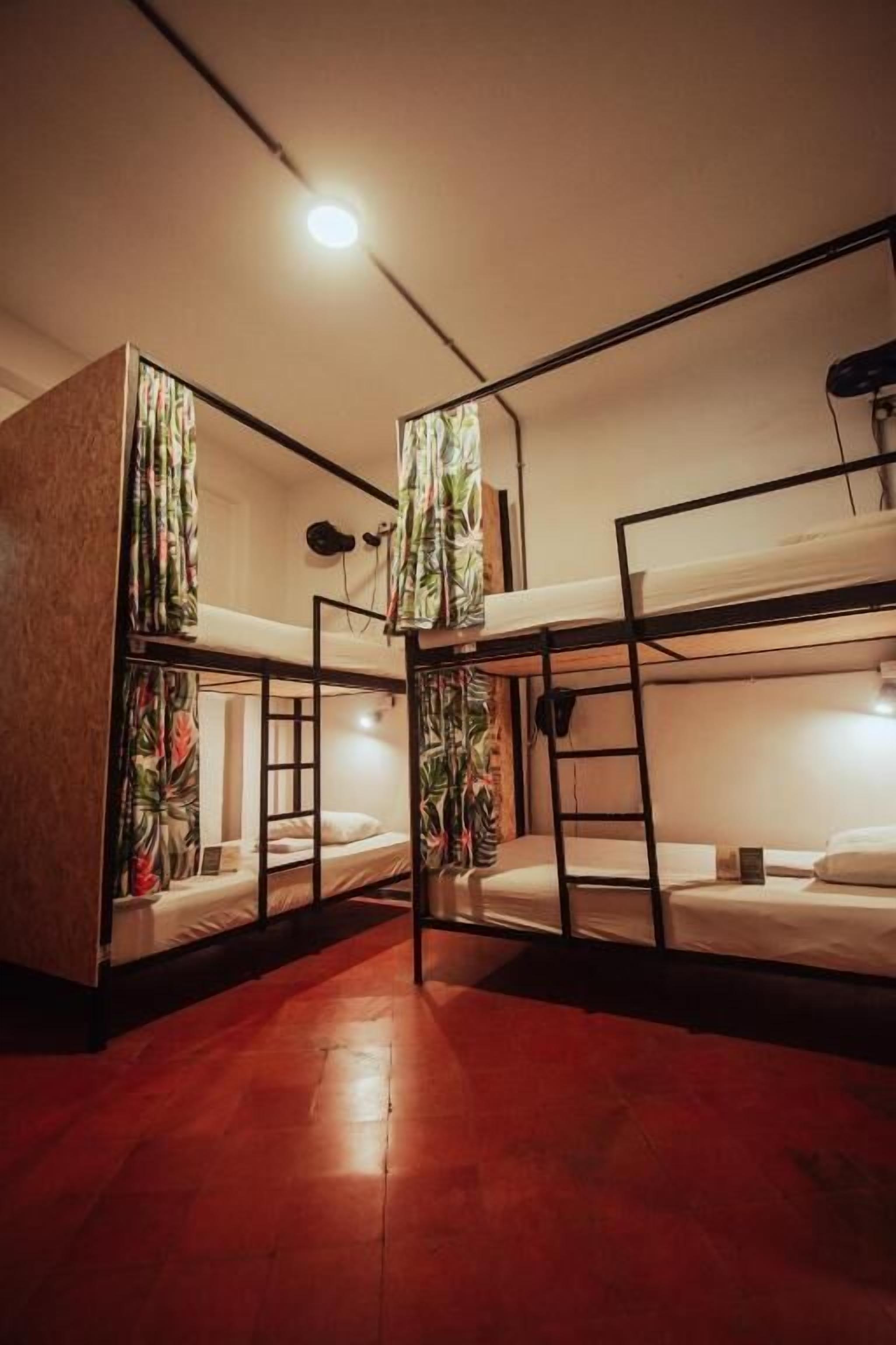Un dormitorio con literas, una escalera y un escritorio pequeño.