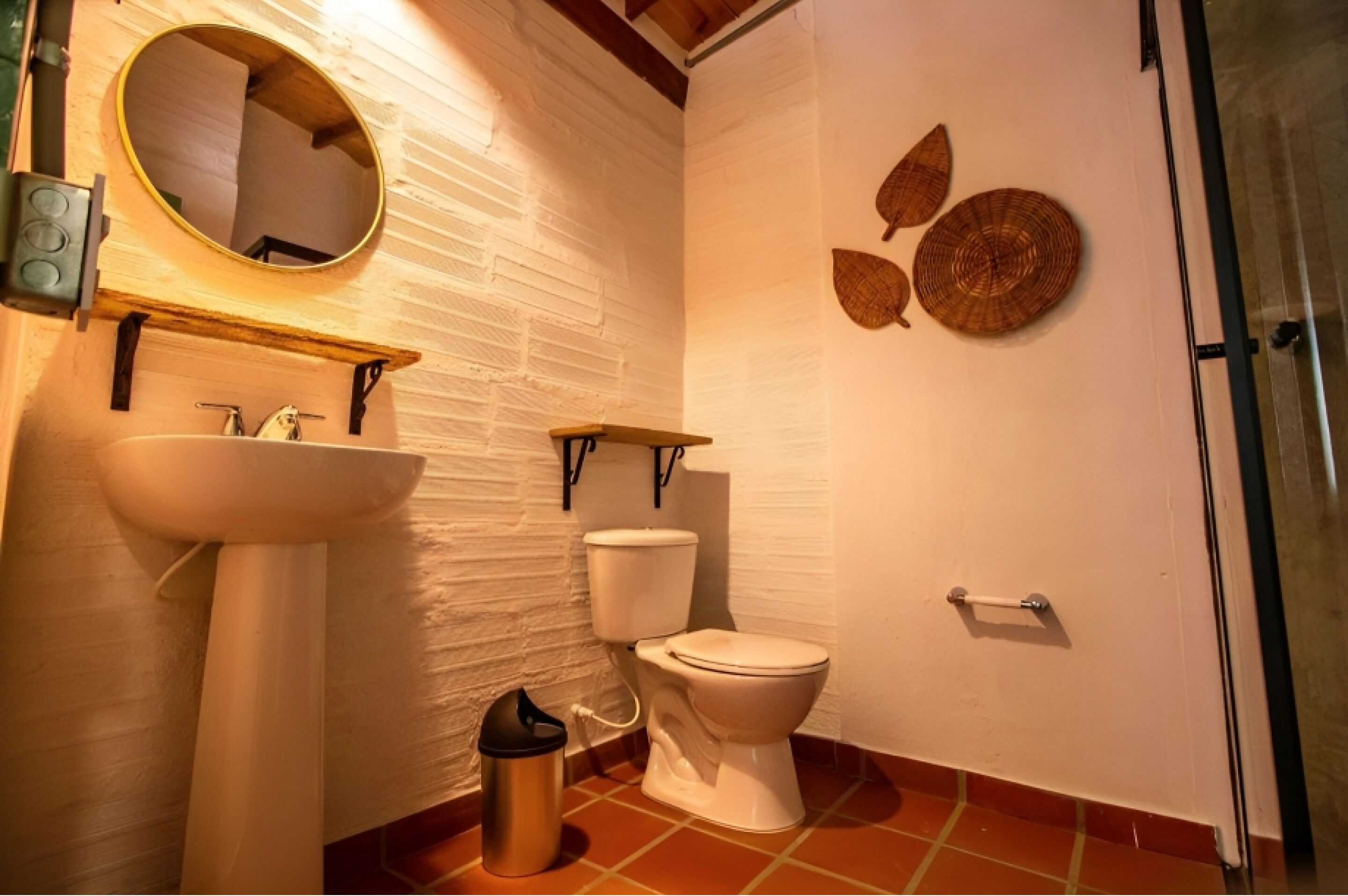 A bathroom with a white sink, a toilet, a mirror, and decorative wall art.