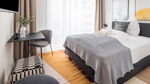 A modern hotel room with a bed, a desk, a chair, and a window with curtains. - Limehome Frankfurt Gutleutstraãÿe (Frankfurt)