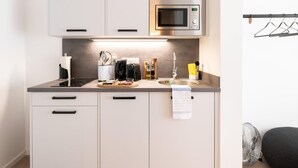A modern kitchen with a microwave, stove, sink, and cabinets.