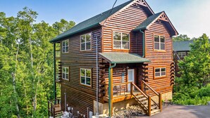 A log cabin with a two-story structure, a front porch, and a visible staircase leading to the entrance. - Private Indoor Pool/Pet Stays Free/HotTub/Movie (Sevierville)