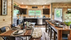 A wooden cabin interior with a kitchen, dining area, and a sign that reads 'COFFEE'. - Private Indoor Pool/Pet Stays Free/HotTub/Movie (Sevierville)