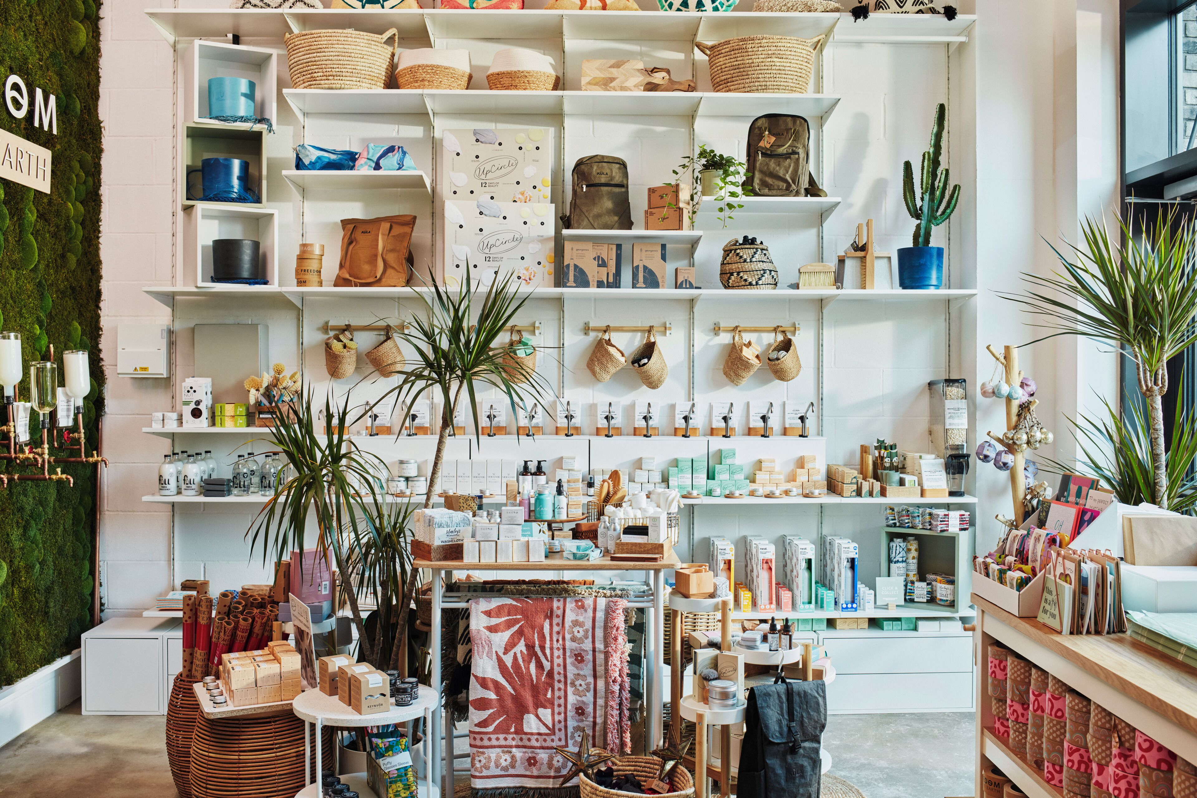A well-organized retail space with shelves stocked with various items, including baskets, bags, and home decor.