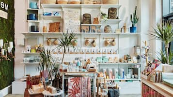 A well-organized retail space with shelves stocked with various items, including baskets, bags, and home decor.