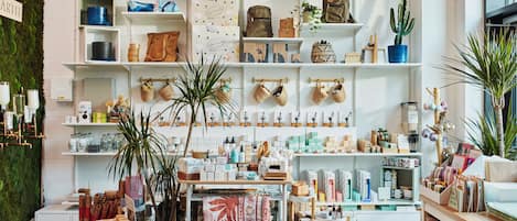 A well-organized retail space with shelves stocked with various items, including baskets, bags, and home decor.