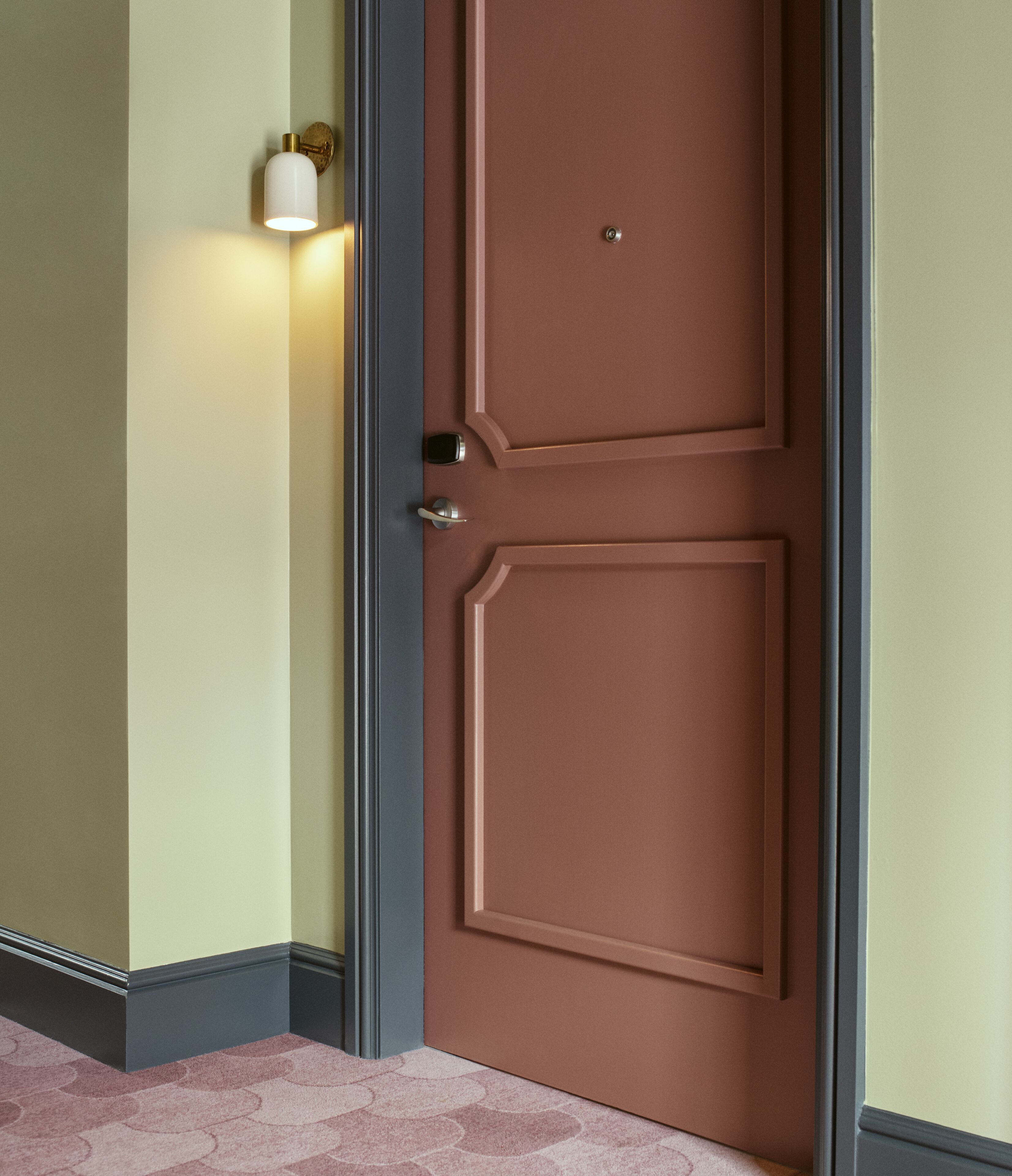 A closed brown door with a small round lock and a keyhole.